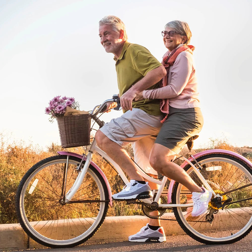 2 ältere Menschen fahren auf einem Fahrrad, schmerzfrei und aktiv - auch im Alter